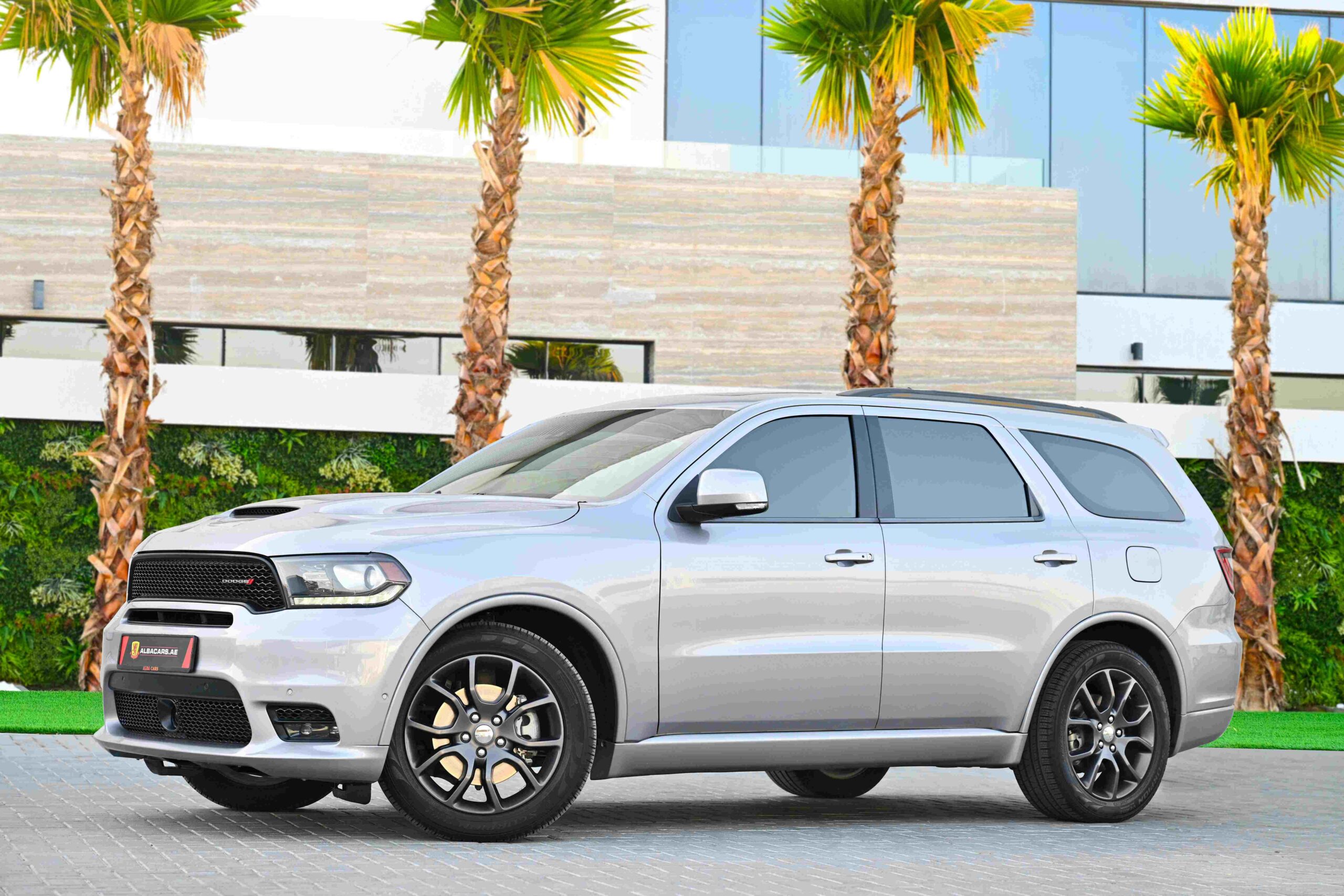 A Dodge Durango parked in front of tropical trees.